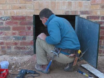 Jeff working on his builder's crack by fitting old access door