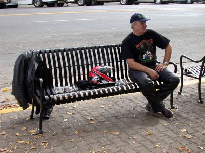 Biker loitering on park bench