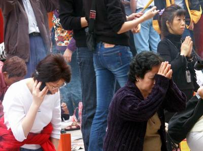 inside a temple: speaking with the gods thru cell phone while other praying in their old-fashion way