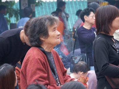 saying her prayer inside the Wong Tai Sin temple