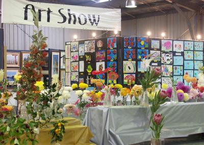 Flower exhibits, children's art in background