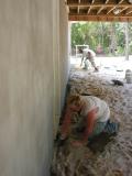 Stucco is applied to the rear foundation