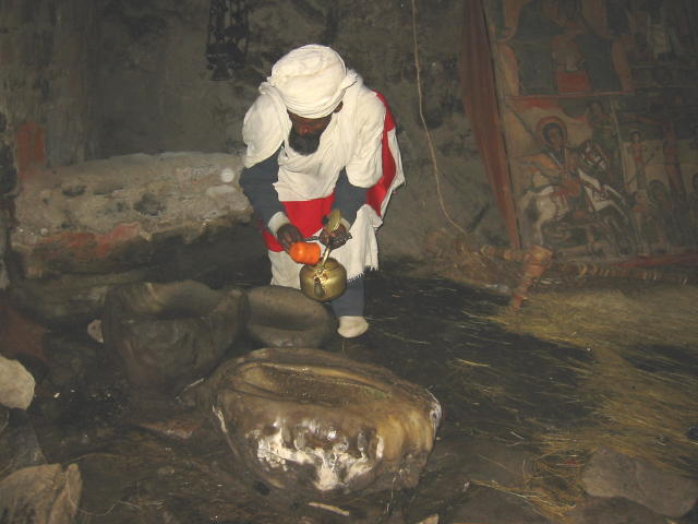 This priest is collecting some <i>tsebel</i> or holy water which has been dripping from the ceilings for hundreds of years
