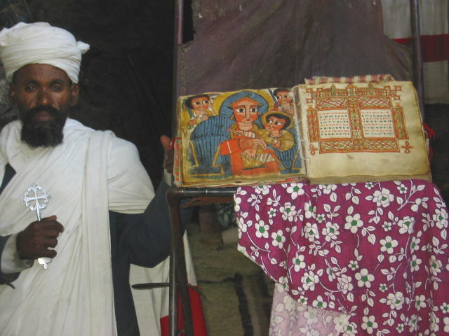 A priest showing an old manuscript, still in use at the church