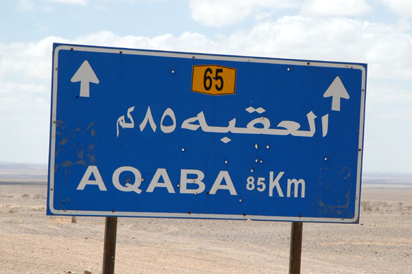 Aqaba 85 km sign shop up a bit
