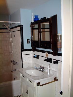 Upstairs Bathroom.  This is the original bathroom for the house.  We maintained the original black & white ceramic tile as well as the black & white hexagonal tile floor.  The original toilet had its wall tank separated via a 90 degree chrome pipe, but it failed from old age corrosion.