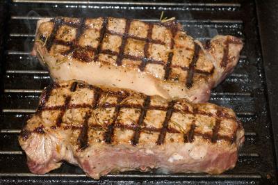 dry aged strip steaks grilling