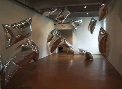Metalic pillows float through the room kept aloft by fans (Warhol museum)