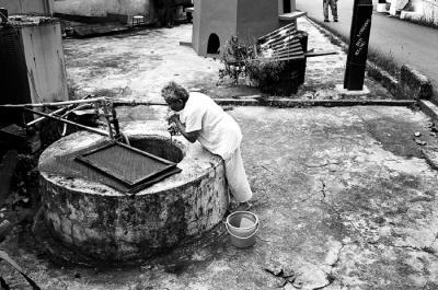Elderly Villager Drawing Water from Well
