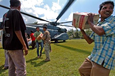 Indonesian citizens carry boxes of noodles