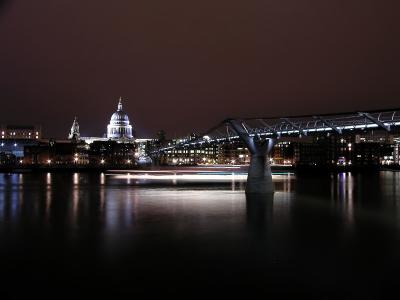 London's Millenium Bridge and St Pauls, cruise ship sailing past.