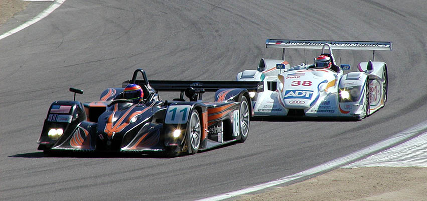 A Lola and an Audi leave turn 3
