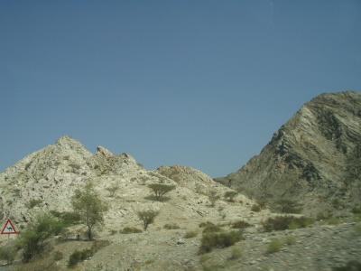 On one side, the rocks are white, on the other, sort of dark brown. NOTE the camel crossing sign
