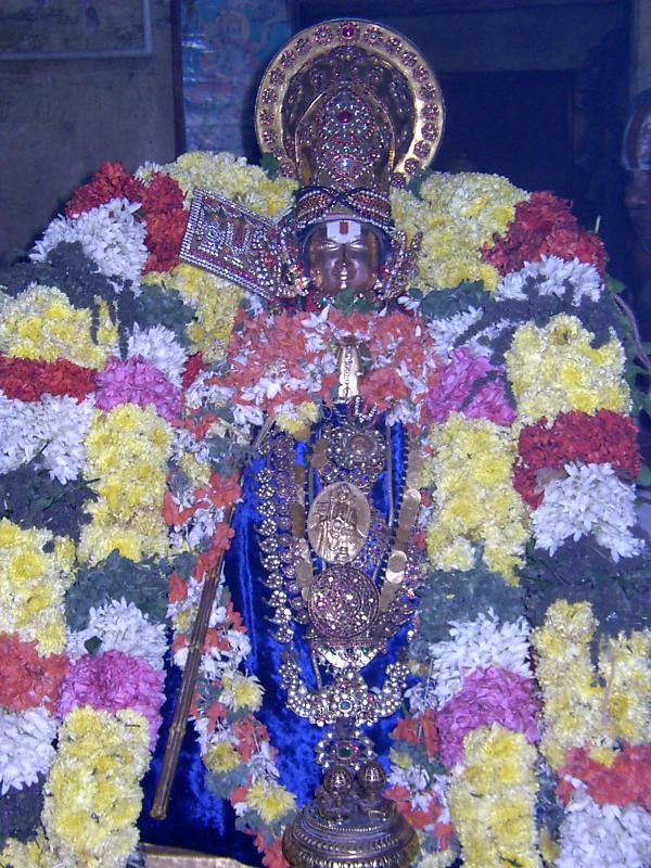 Embar enjoying adorning the soodikkalaintha mAlai of Sri Parthasarathi emperuman very close to his thirumeni