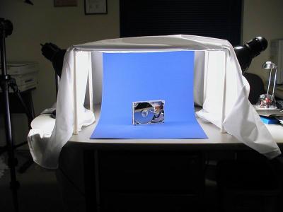 You can also pull the sheet over the front and cut a hole just for the lens. I have at times use a light on top, I have a plan desk light that I use for that.

Watch the heat of the lights, they do get hot and you don't want them to come in contact with the sheet.