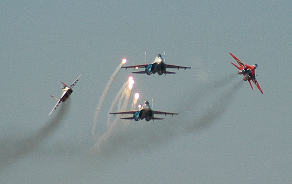 Su-27 deploying flares as the MiG's break off