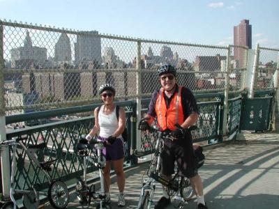 Brooklyn-bound on the Manhattan Bridge's bike and pedestrian path, a smiling Sharon Anstey on her Microbike with TU's John Chiarella on his Dahon.