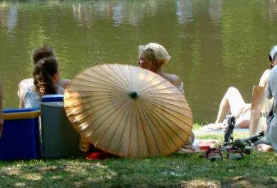 Scenic pond in Het Park. People enjoying the fair weather