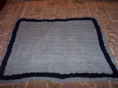 I didn't use a very good background for this photo.  It's hard to tell but the dark blue in the border is very thick and bubbly-looking.  It took as much yarn for it as the entire light blue inside square, and as much time to do as well.  
