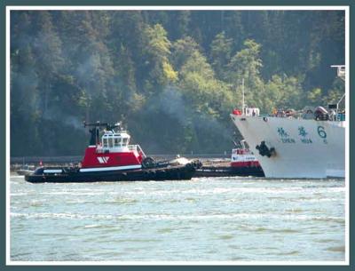 Berthing tugs assist the incoming ship.