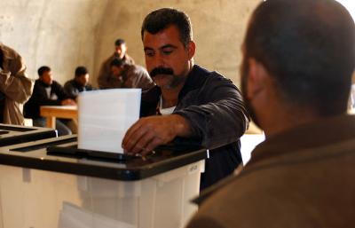 An Iraqi voter casts his ballot