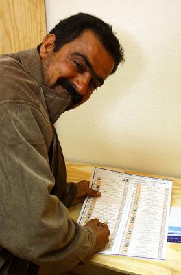 An Iraqi citizen fills out his ballot