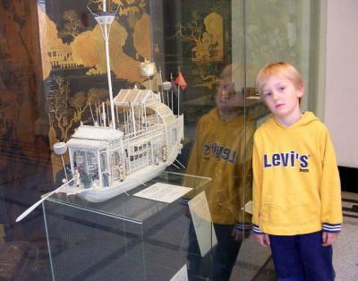 Carved ivory Chinese boat, ca. 1800; sweatshirted American boy, 1999