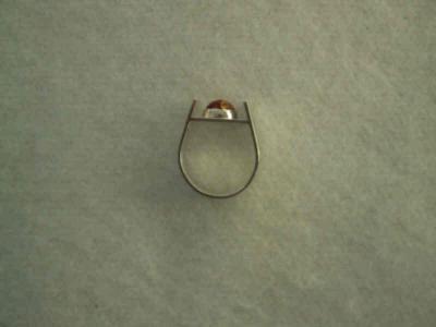 Round amber cabochon set in a horse-shoe style ring.