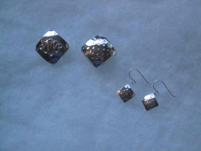 Called 'pillow beads' because of their shape.  The two large beads are together to illustrate that the opposite sides bear a different design.  The pendants can be worn on a satin rope or chain.