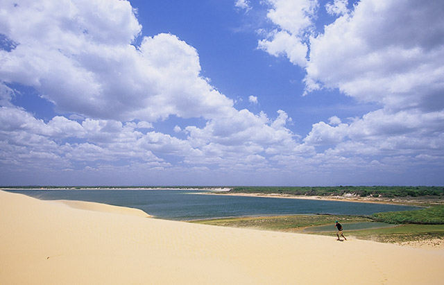 Turista subindo duna ao lado da lagoa do boqueiro, Camocim