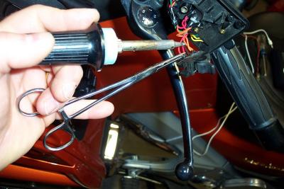 A hemostat works as a third hand for unsoldering wires from switches