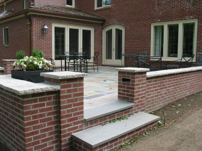 brick wall to match the house and edan stone cap frameing bluestone patio