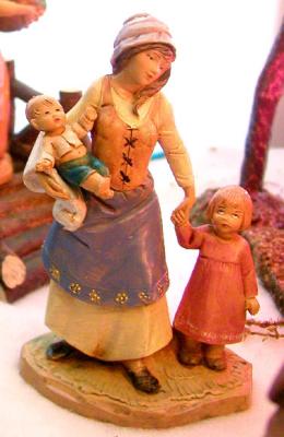 A mom brings her kids to the see the baby Jesus.