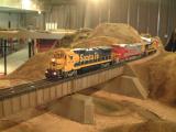 Santa Fe express train trundles across a trestle over a dry creek bed.