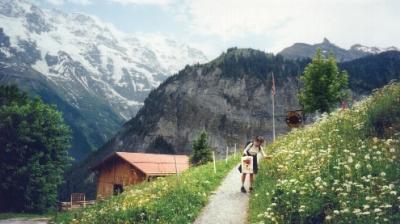 Judy picking wildflowers on a trail in Gimmelwald.