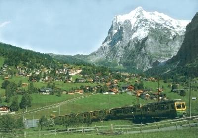 A local train approaching Grindelwald, which is seen in the background.