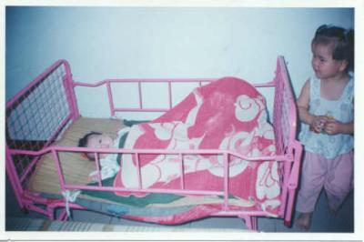 Toddler with baby in crib.jpg
