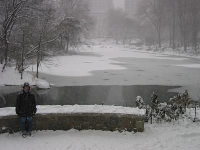 Chelle stands in front of The Pond. The snow is coming down at a good rate.
