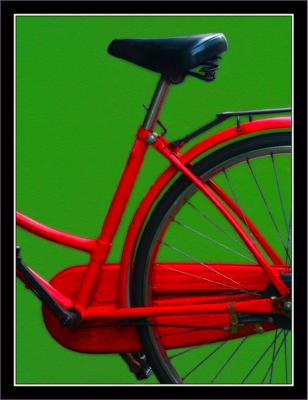 Red bicycle on green wall