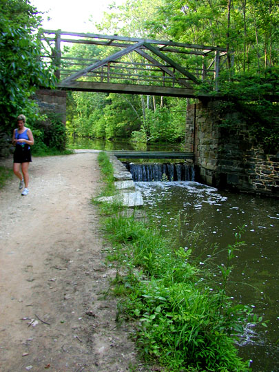 A bridge over the canal leading to a parking area alongside a nearby road