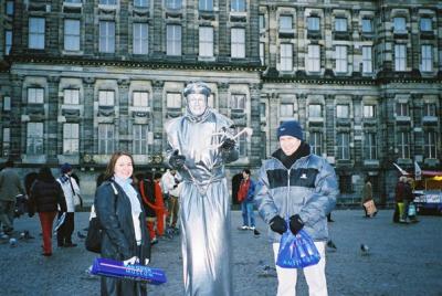 With one of those 'artists' in Dam square.  He wouldn't pose without pointing at his euro filled cap on the ground, hint, hint.