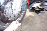 Removing the lower left brake caliper bolt with an allen socket bit