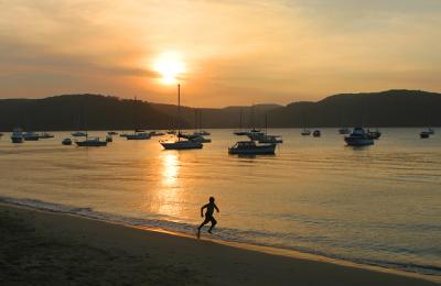 Silhouette of boy running at Pittwater sunset