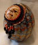 Egg rattle with beaded face.  Hes made with a chicken egg.