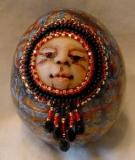 Egg rattle with beaded face