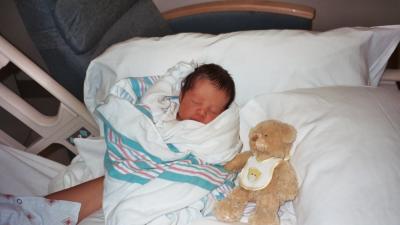 Evan sleeping on Mama's lap next to his bear