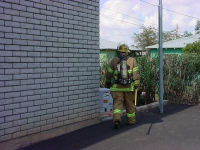 49. one fireman walking around ne corner of building