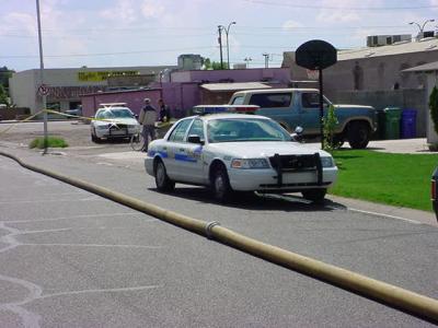 66. police cars, firehose on ground and yellow tape