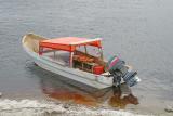 Taxi boat with an orange tarp roof