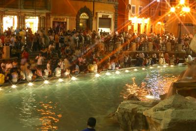 Crowd alongside the Trevi Fountain at night in Rome, Italy.